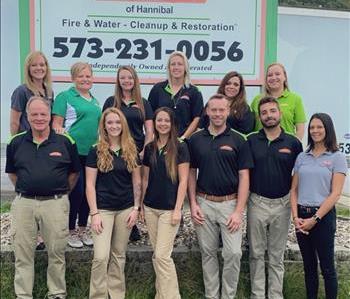 Group photo of owners and employees in front of a SERVPRO of Hannibal sign