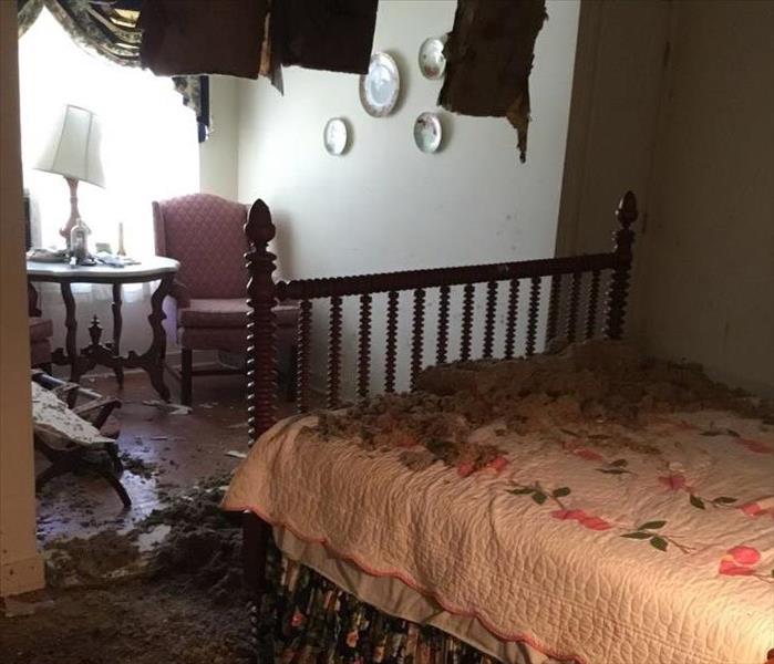 Ceiling in bedroom caved in with debris on the floor